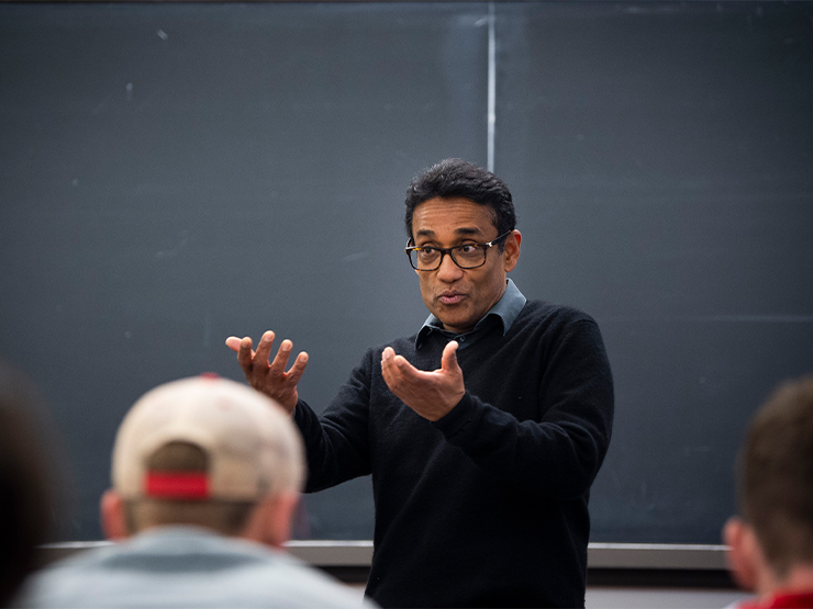 A male political science instructor speaks to a a classroom of students.