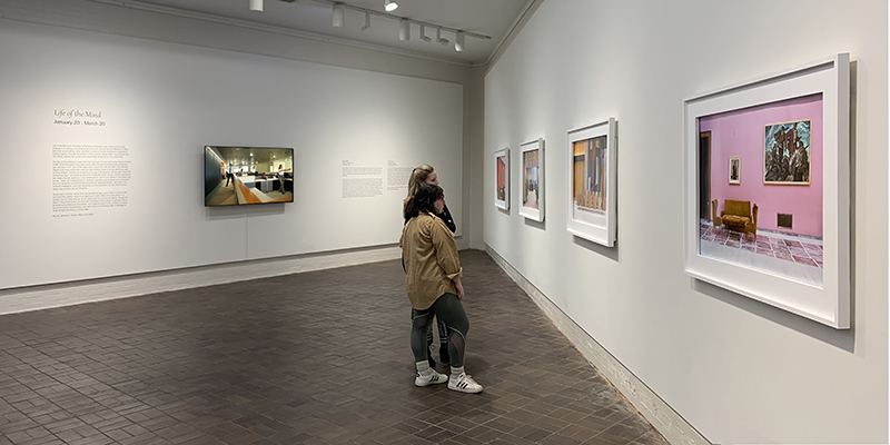 Two people walking through gallery during the Life of the Mind Exhibit