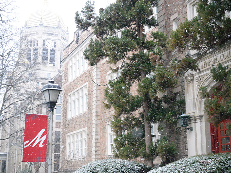 A flurry of small snowflakes fall along a row of academic buildings on the campus of Muhlenberg College.