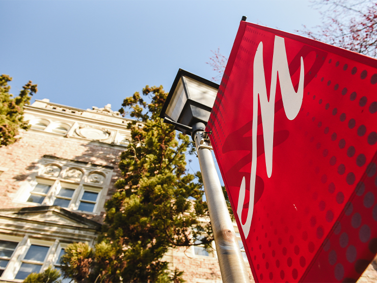 A red banner with a stylized M hangs from a light pole.