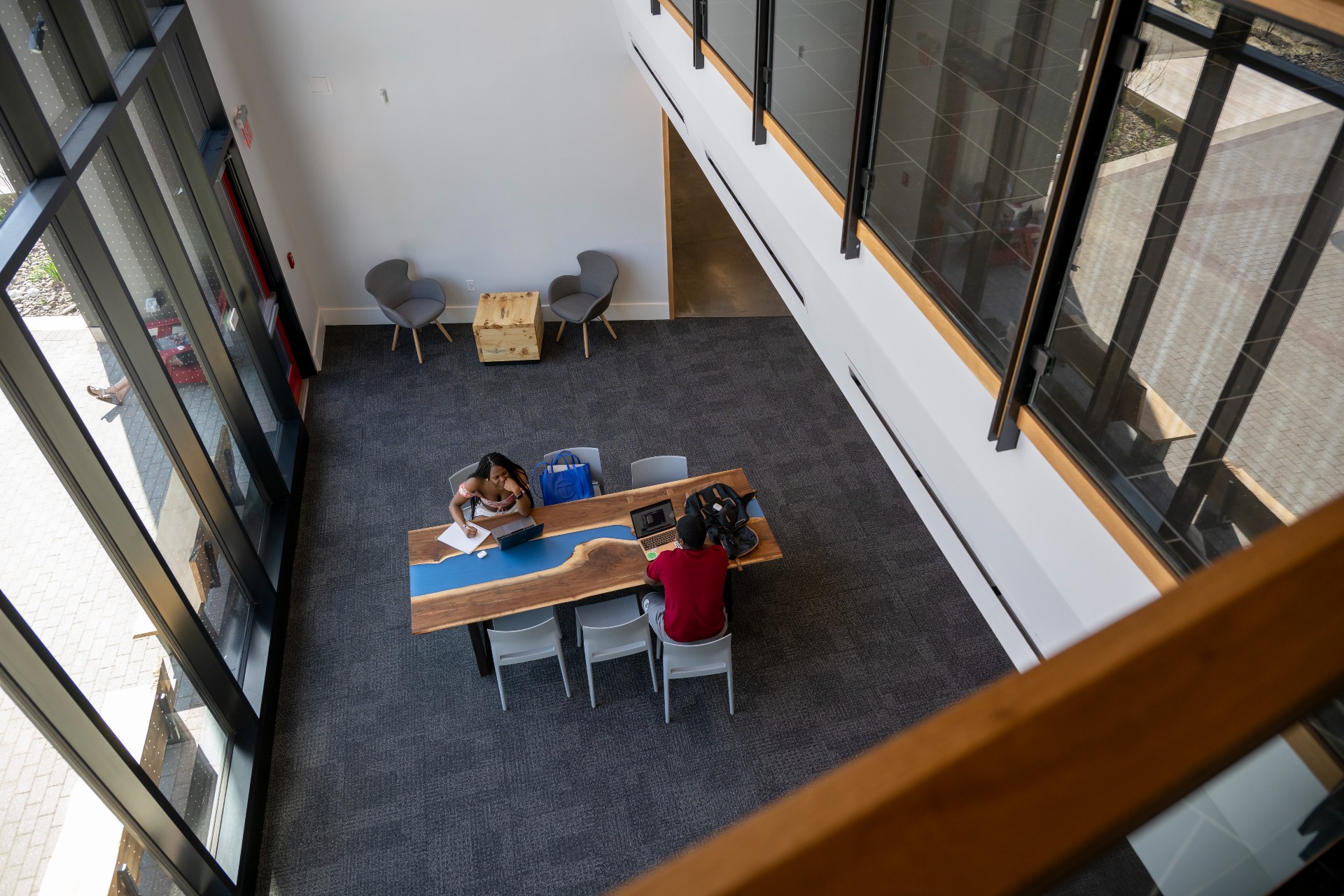 Two students sit at a table inside Fahy Commons