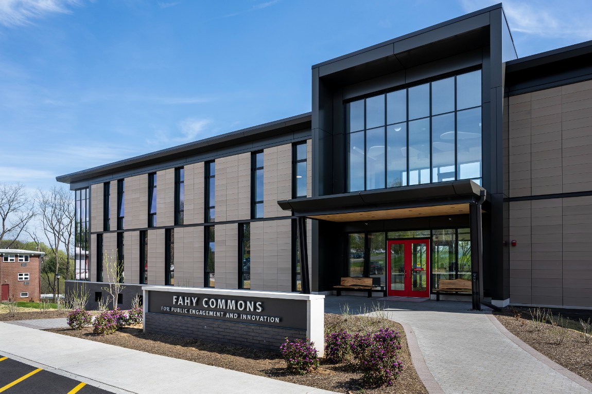 The front of a modern building with large windows and red doors.