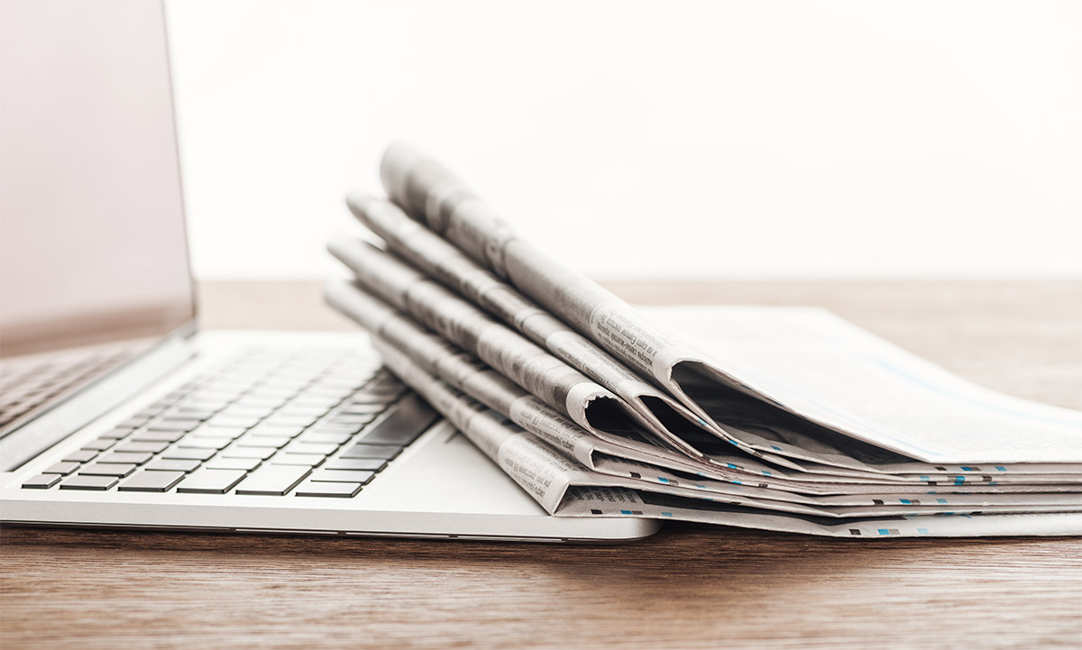 image of a newspaper and laptop