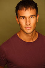 A headshot of a young actor in a red crew neck T-shirt