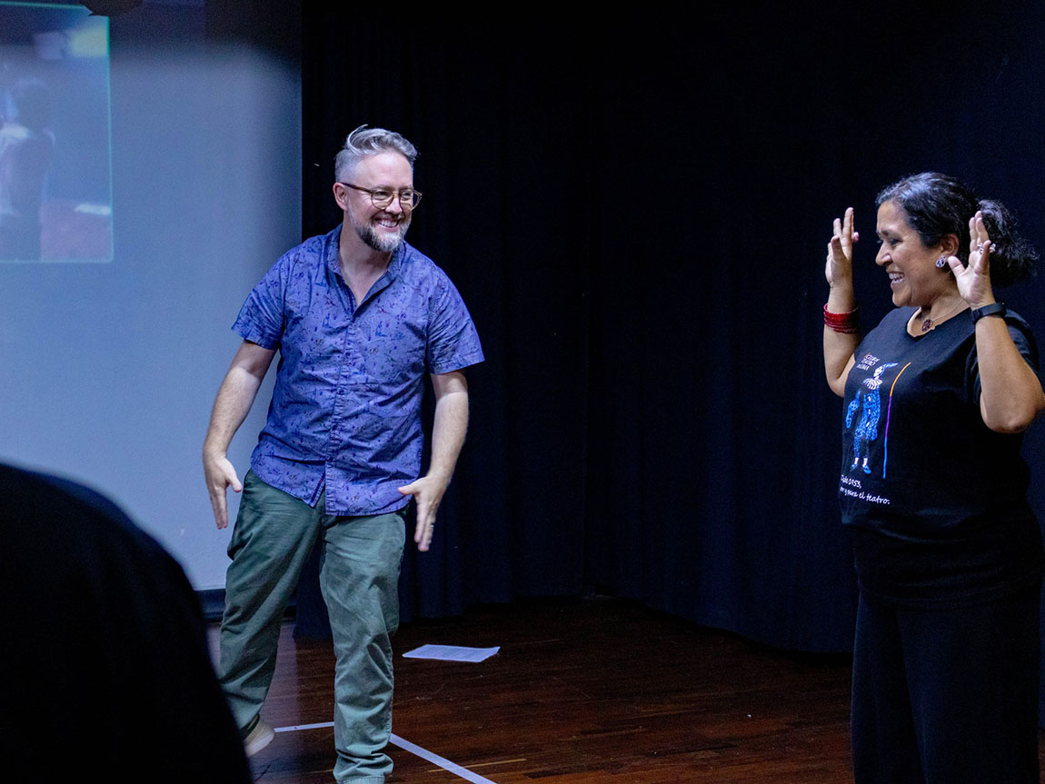 Two college theatre professors work together as they teach on a stage