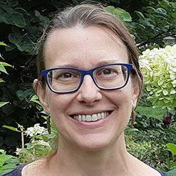 A headshot of Katie Bucher, who has glasses and long brown hair pulled back