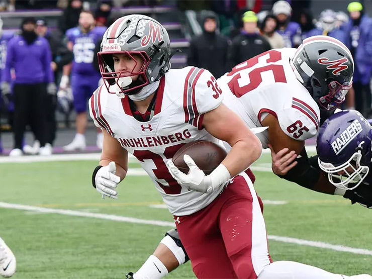 A Muhlenberg football player runs with the ball.