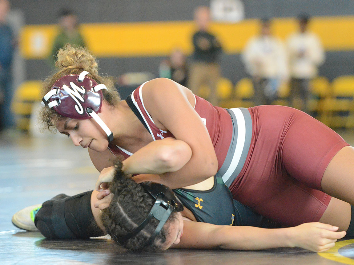 Two college women's wrestlers grapple on the mat