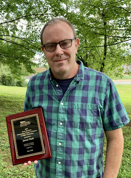 Theatre Professor James Peck holds the Oscar Brockett Award. Text reads 