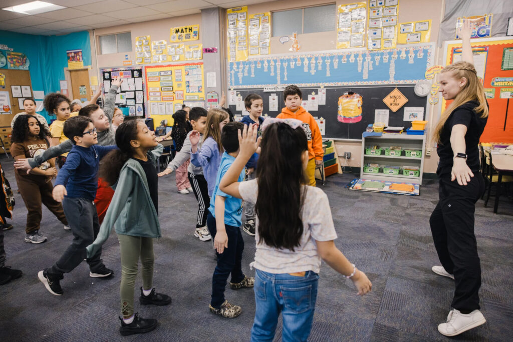 A Muhlenberg education and dance student leads a classroom of elementary school children in guided movement.