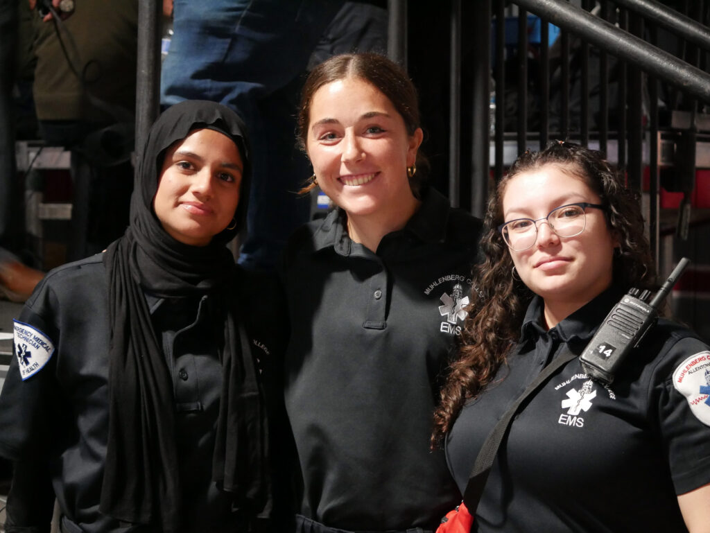 Three college students wearing EMS uniforms