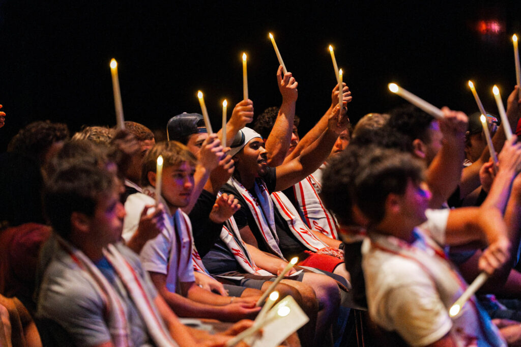 Muhlenberg College students hold up battery-operated candles