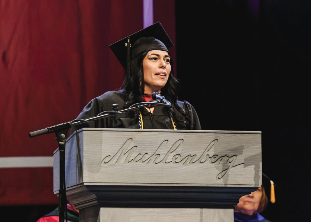 Photo of Christine Compton speaking at graduation from behind a podium