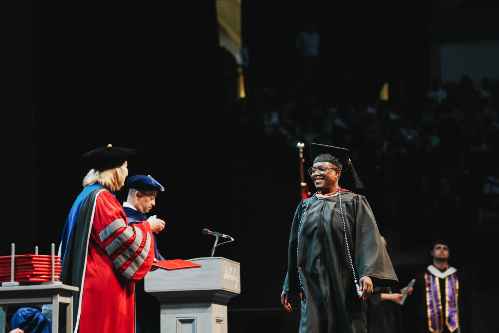 A college gradaute walks the stage at commencement