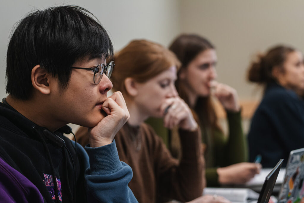 Students listen pensively in a classroom.
