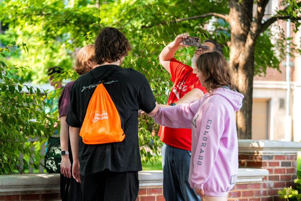 A Muhlenberg College family puts their hands in the middle for a photo during orientation