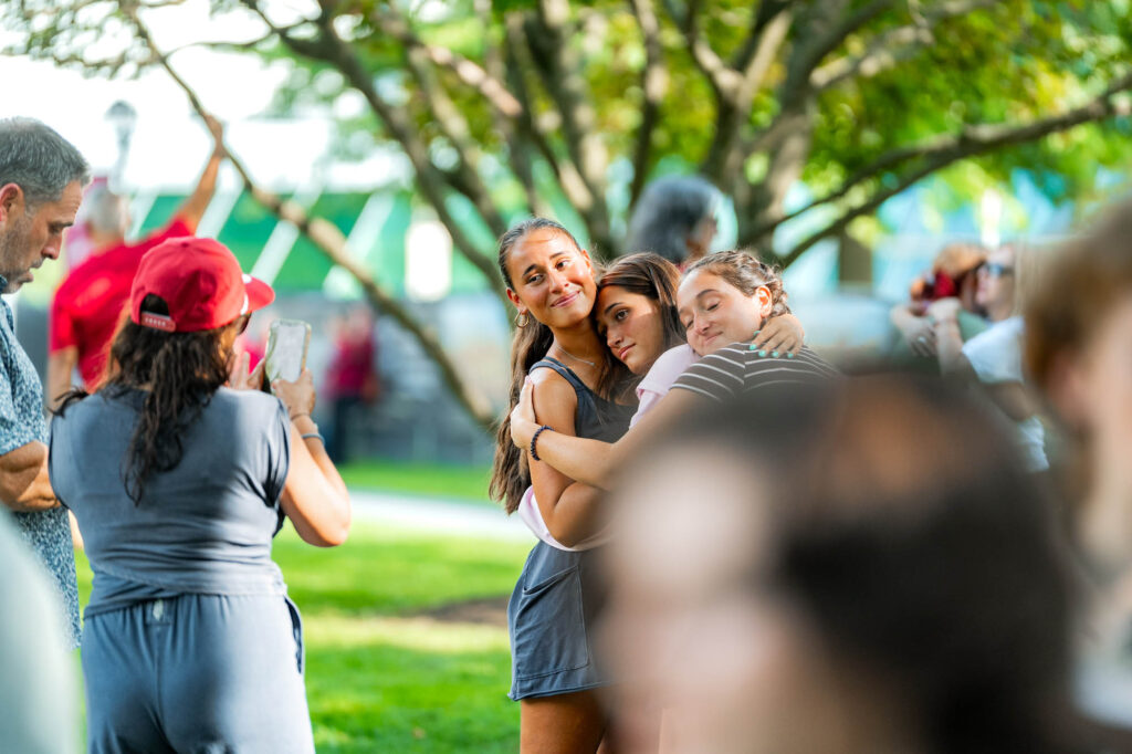 Three teenagers hug during Muhlenberg College orientation