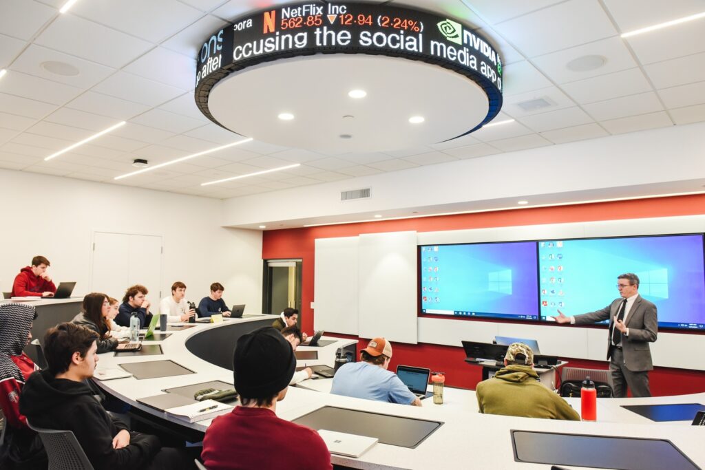 A professor lectures a class in the Finance Lab.