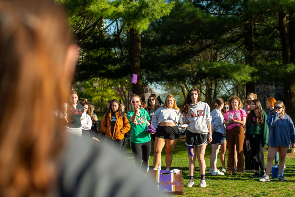 A college student throws a beanbag on the college green