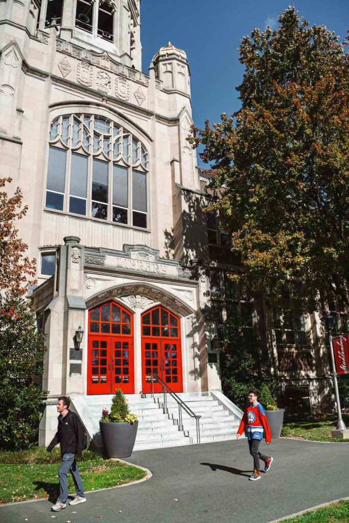 An academic building with red doors on a college campus