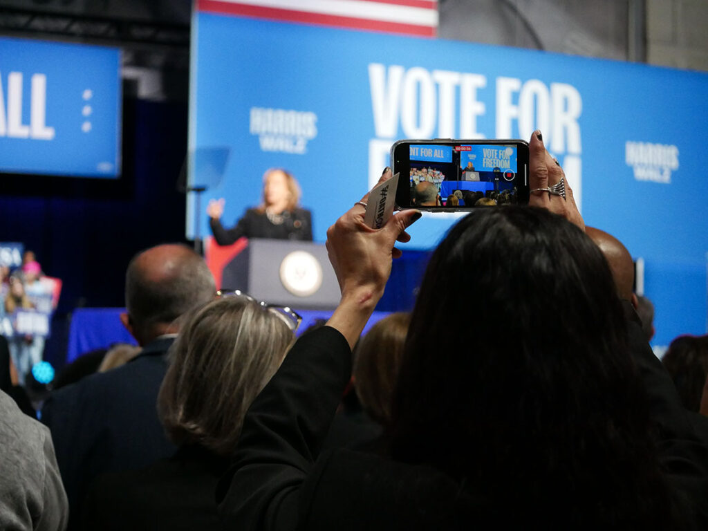 Attendees take pictures of Harris during rally on campus.