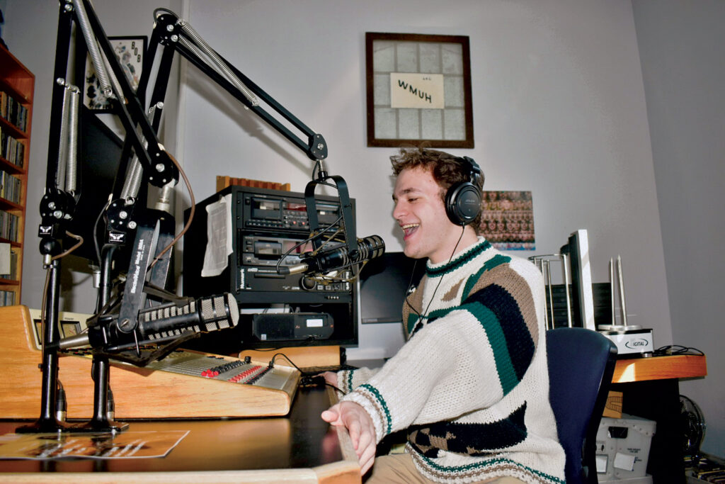 A college student speaks into a microphone in a radio studio