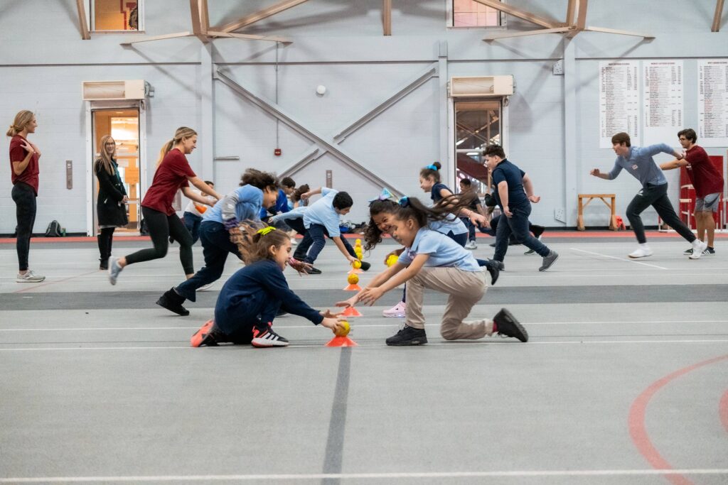 Elementary school students compete in a game in a college gym