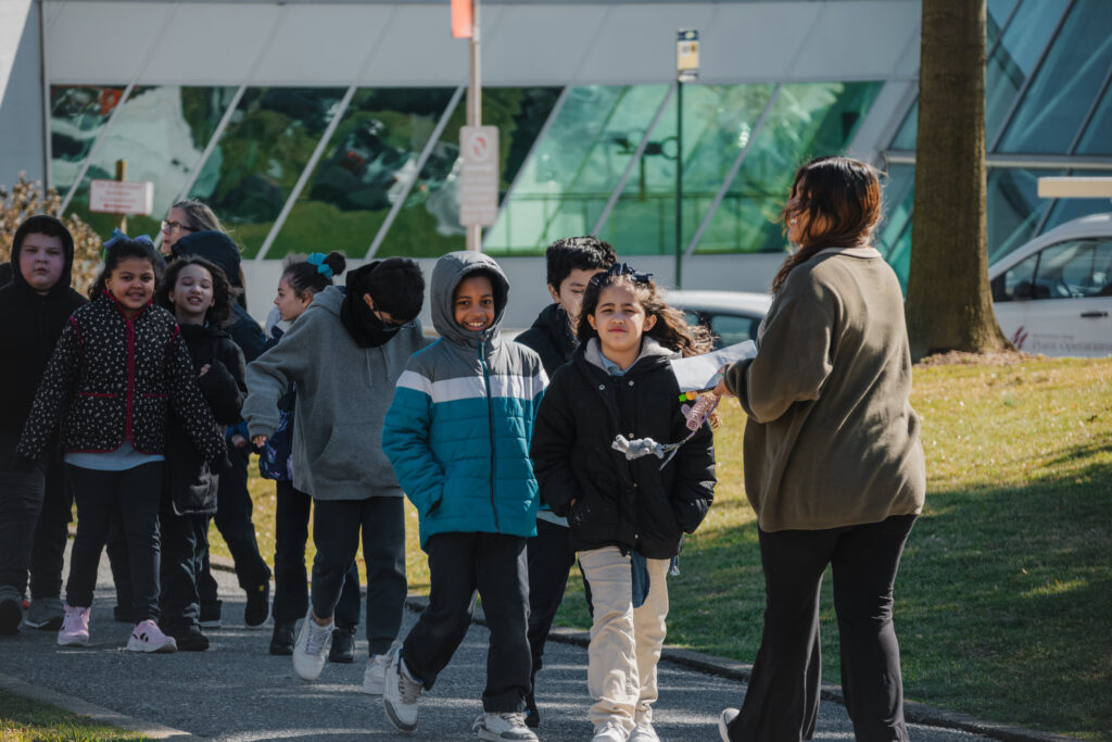 A college student gives a campus tour to a group of elementary school students