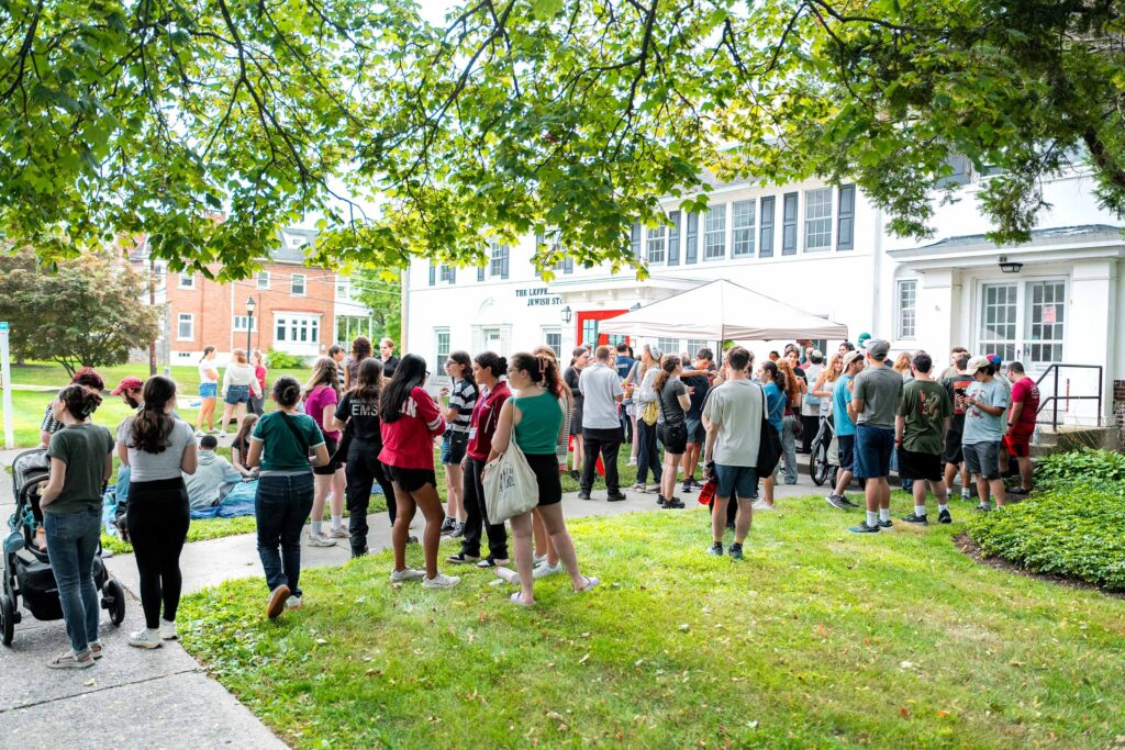 A large group gathers on the lawn of Hillel for a welcome event