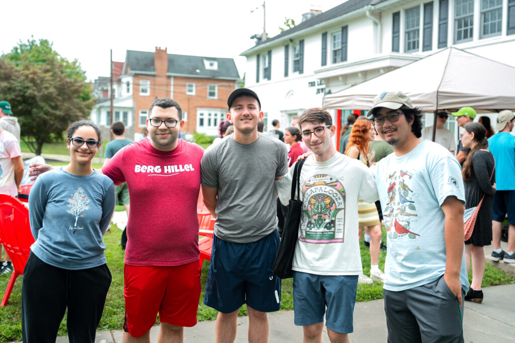 Five college students pose for a photo in front of the Leffell Center for Jewish Student Life