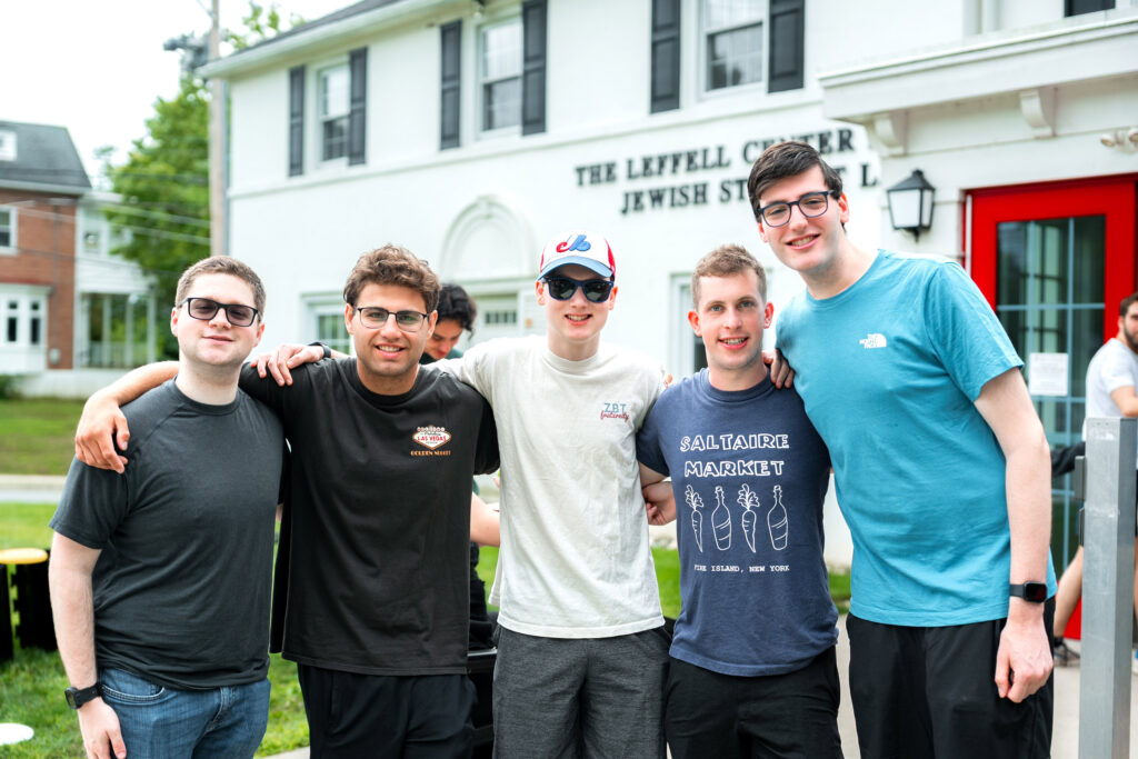 Five college students pose for a photo in front of the Leffell Center for Jewish Student Life