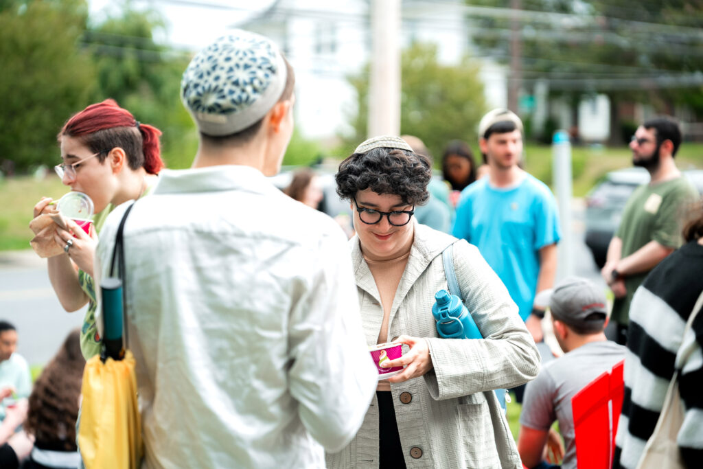 Two college students in yarmulkes talk to each other outside