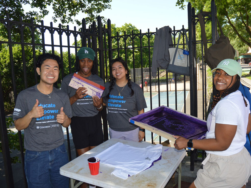 A group of college students print t-shirts.