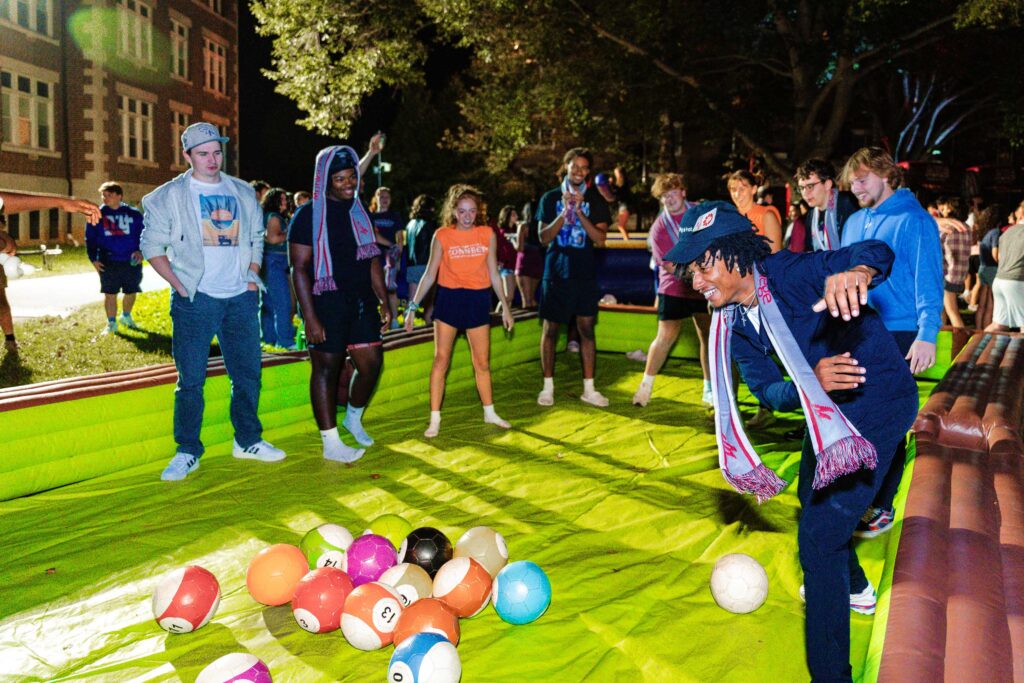 College students play a giant game of pool outside at night