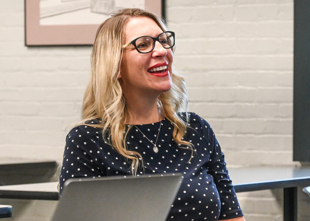 Photo of Lauryn Graves laughing while sitting in a classroom