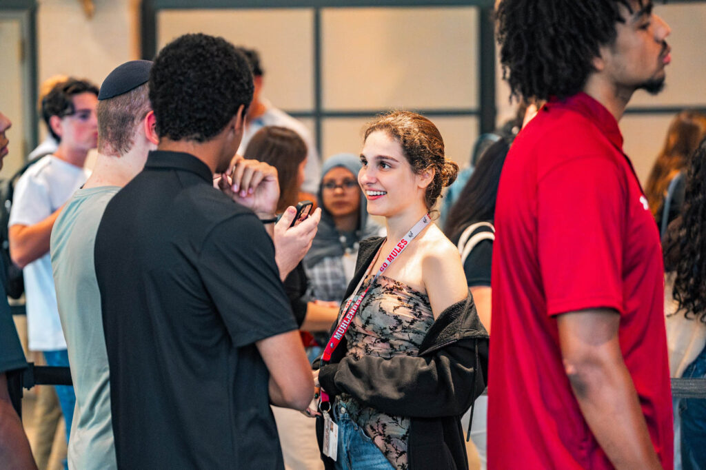Muhlenberg College students converse inside an academic building