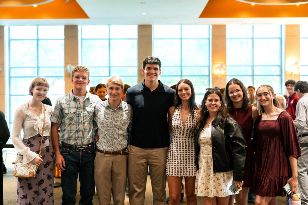 A group of new Muhlenberg College students inside with windows behind them