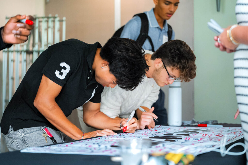 Two Muhlenberg College students sign a Class of 2030 banner