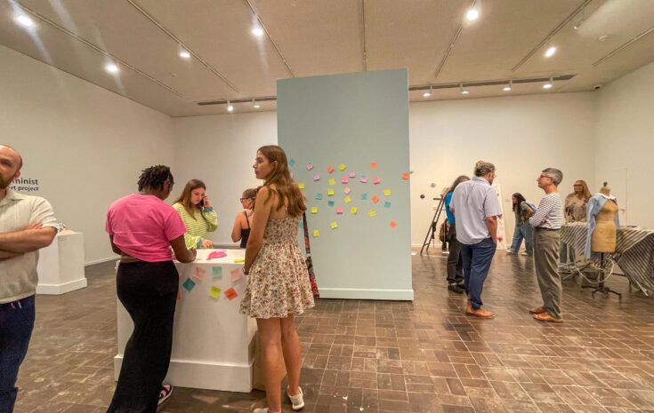 People attend an exhibition in an art gallery