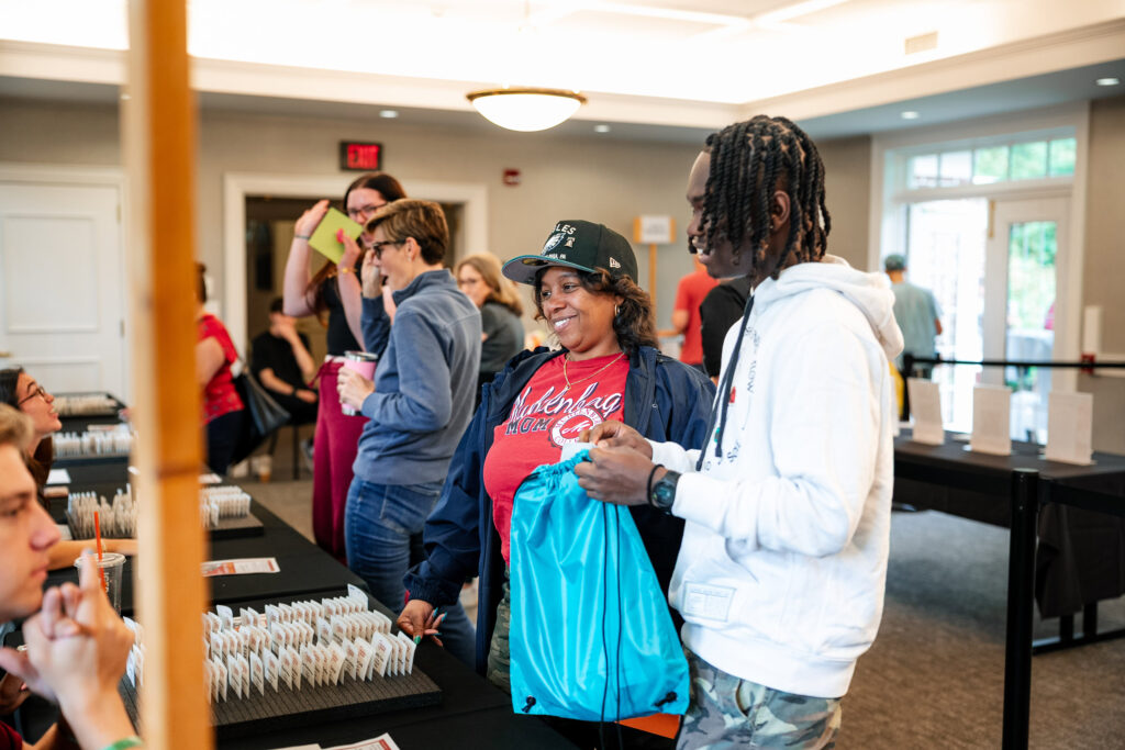 A college student and his mother check in to receive his room key