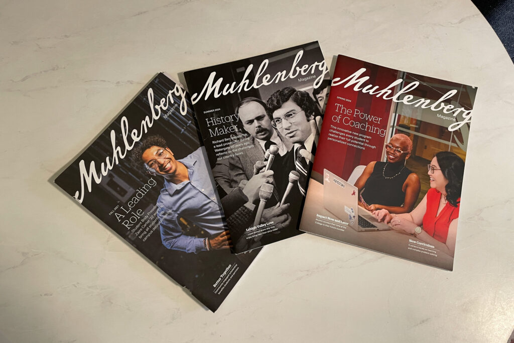 Three issues of Muhlenberg Magazine on a white table