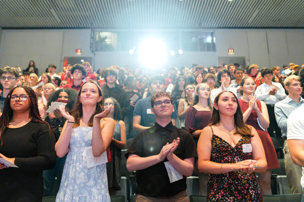 Muhlenberg College students stand in an auditorium