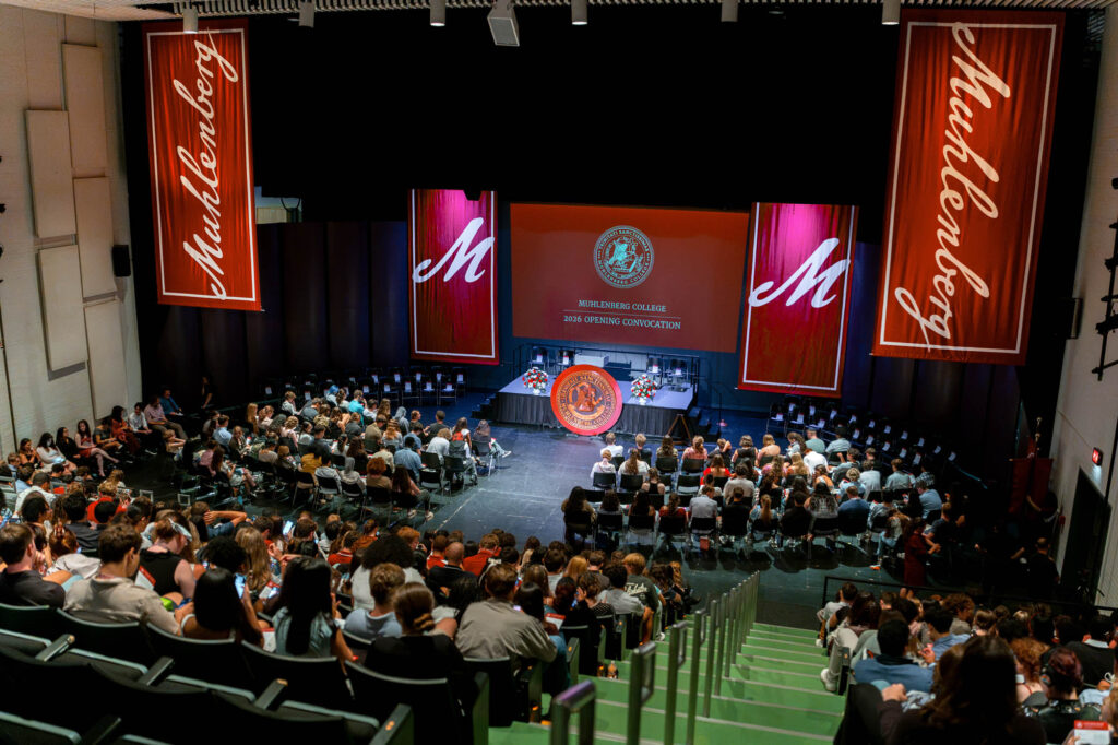 A stage in a Muhlenberg College theatre surrounded by students in chairs