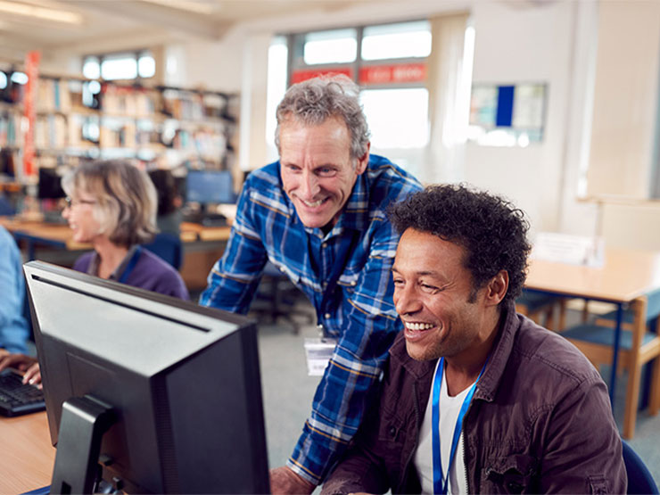 teacher and student look at computer