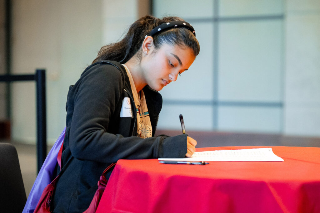 A college student signs a piece of paper
