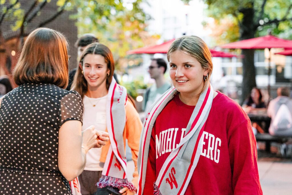 A Muhlenberg College student smiles after receiving a scarf during orientation weekend.
