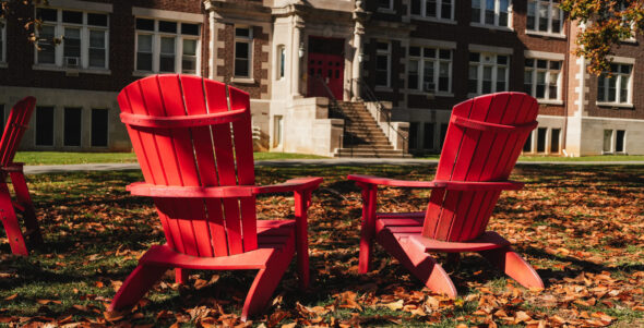 two red chairs in autumn leaves