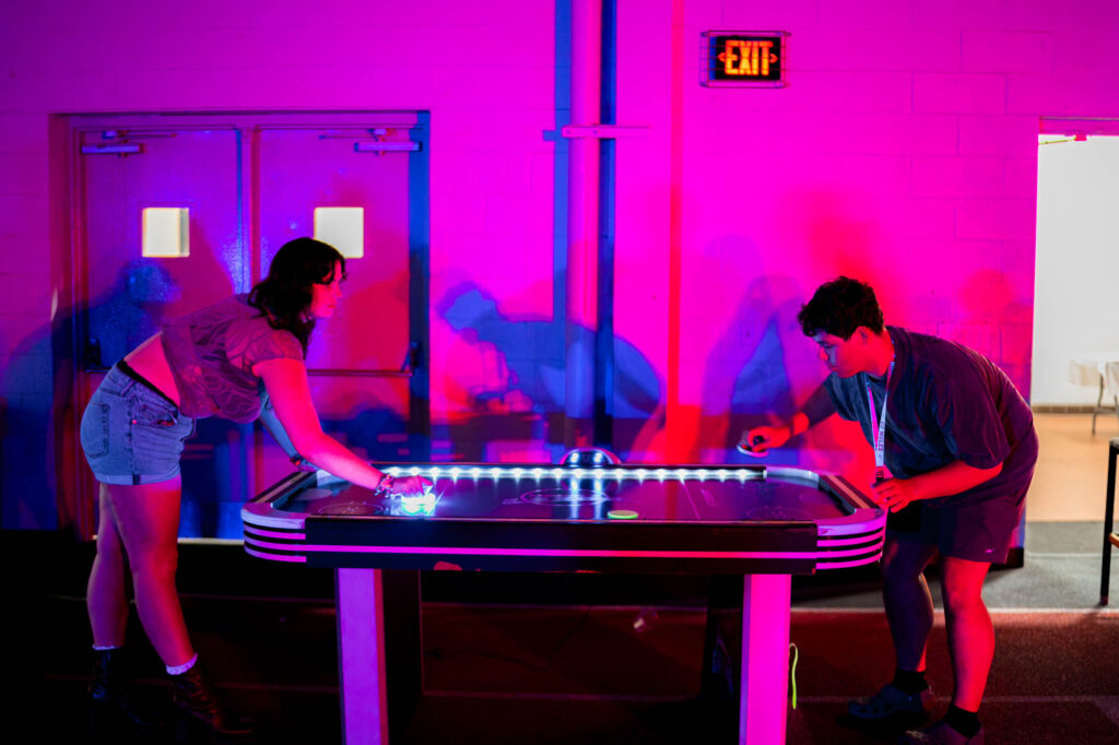 Two Muhlenberg College students play air hockey in the field house