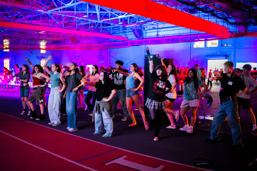 Muhlenberg College students participate in a video game that requires dancing during a welcome party in the field house