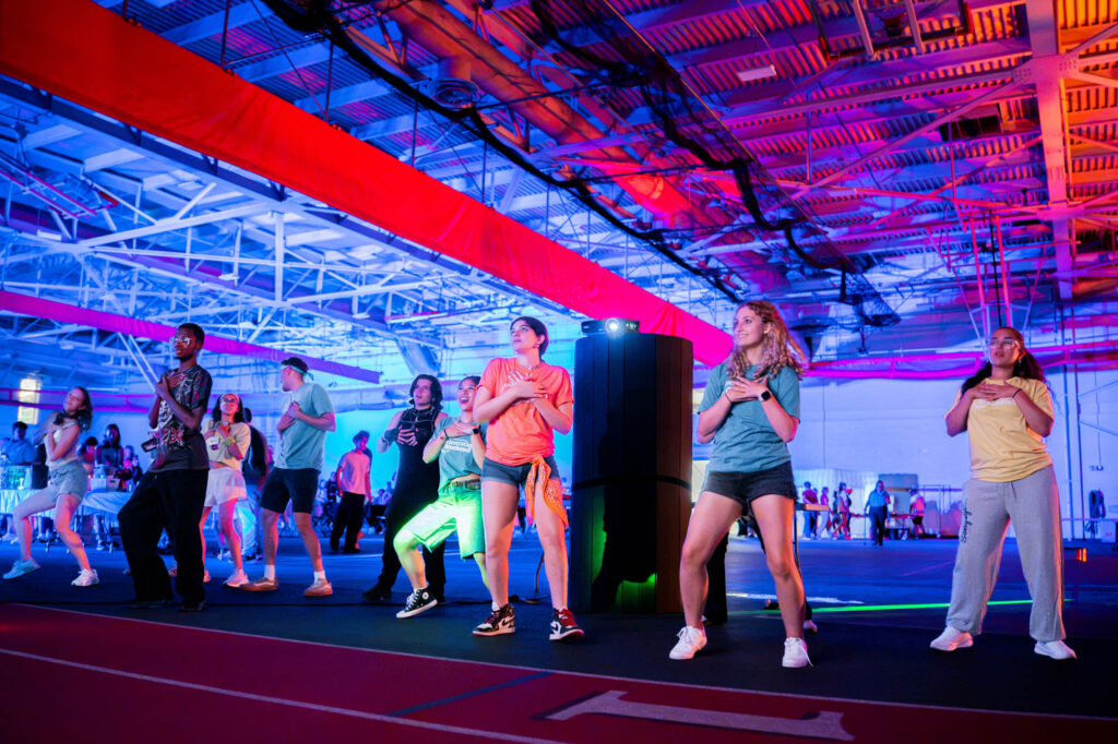 Muhlenberg College students dance while playing a video game at an orientation welcome party